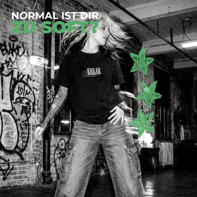 Femme en t-shirt Kailar devant un mur de graffitis, avec le texte « Normal ist dir zu soft? »